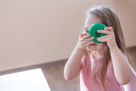 the child plays with a detail from the pyramid. the girl looks through the hole in the wheel. Concept of fine motor skills development, educational games, childhood, children's day, kindergarten, house arrest copyspaceの写真素材