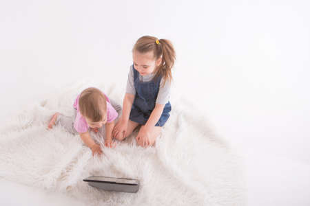 the kids are watching cartoons on the tablet. Home schooling for girls during quarantineの写真素材