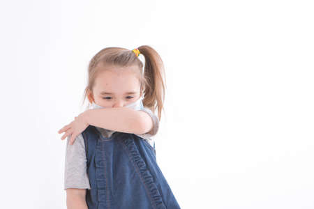 Portrait of a child on a white background who wears a medical mask. Demonstration of medical equipment. The girl sneezesの写真素材