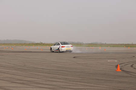 advertising BMW, Moscow, 1.11.2018: demonstration of the white car model, cars in the test track, dust from under the wheels, tracks on the road, race, driving training in a driving school, delivery around the city, taxiのeditorial素材