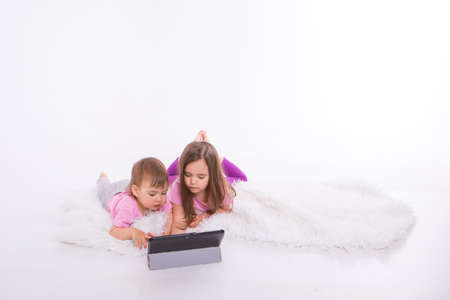 the kids are watching cartoons on the tablet. Home schooling for girls during quarantine
