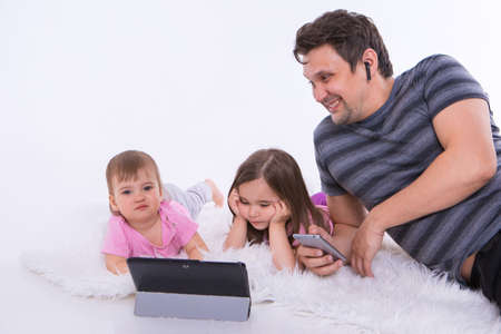 modern technologies in everyday life: a man talks on the phone through a headset, children watch a...
