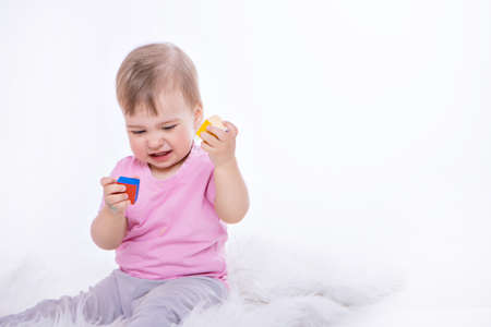 a child plays with colorful figures. Details of the toy in the hands. Girl holding a diceの写真素材