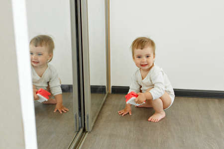 a small child cleans the house. The girl washes the mirror. restoring order in the apartment