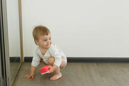a small child cleans the house. The girl washes the mirror. restoring order in the apartment