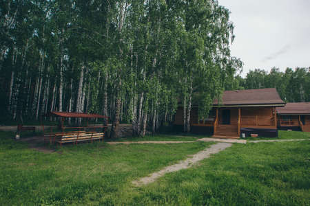 summer wooden house in a birch grove. camping in the woods. tourist base for travelers' recreation. eco-friendly constructionの写真素材