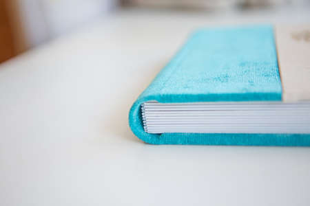 Diary close-up on a white background. the cover is white and blue. the best gift - a photo album