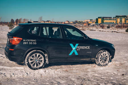 BMW advertising, Moscow, 1.11.2018: demonstration of a model of a black car, cars on a snow-covered road, racing in extreme conditions, driving training, delivery, taxiのeditorial素材
