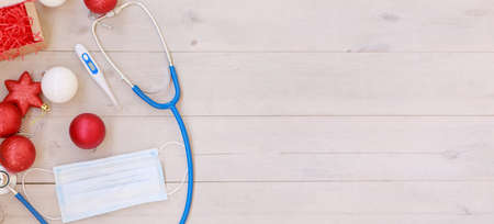 Christmas decorations and medical devices: mask, stethoscope and thermometer. Copy spaceの写真素材