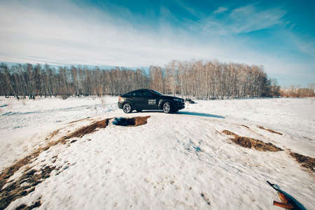 BMW advertising, Moscow, 1.11.2018: demonstration of a model of a black car, cars on a snow-covered road, racing in extreme conditions, driving training, delivery, taxiのeditorial素材
