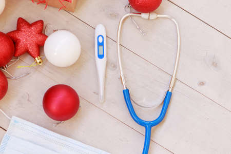 Christmas decorations and medical devices: mask, stethoscope and thermometer. Copy spaceの写真素材