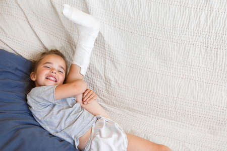 broken leg. Close-up of the cast on the feet. exercises to repair and strengthen muscles. damage to the bones. medical care of a surgeon in the emergency roomの写真素材