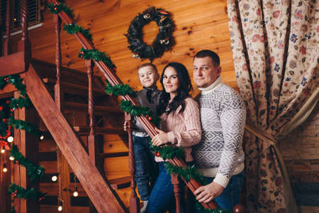 The family celebrates Christmas together. parents with a child among the festive interiorの写真素材