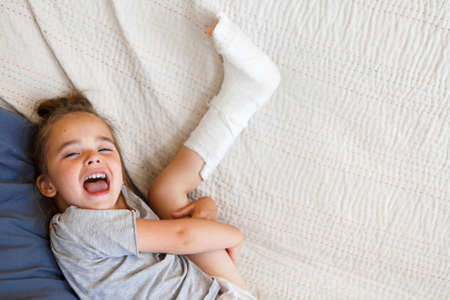 broken leg. Close-up of the cast on the feet. exercises to repair and strengthen muscles. damage to the bones. medical care of a surgeon in the emergency roomの写真素材