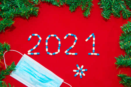 Christmas decorations and medical devices: mask, pills. Copy space on a red background