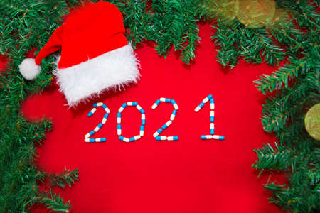 Christmas decorations and medical devices syringe and santa hat. Copy space on a red background