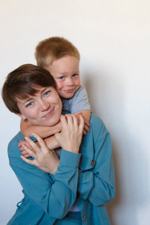 mother's day. mother's love. A happy mom with son in blue cloth embrace. Isolated on a white...