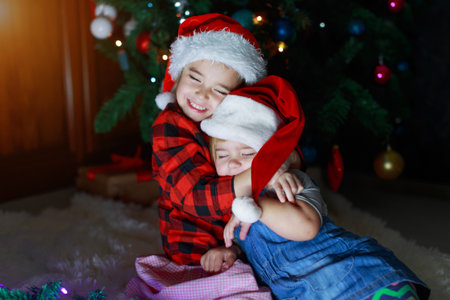 girls in red Santa hats. sisters in Christmas costumes.の写真素材