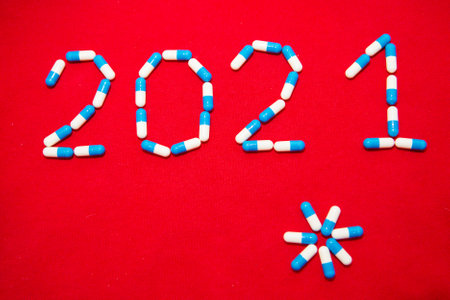 Holiday in self-isolation, hospital. Christmas decorations and medicine. Copy space on a red...