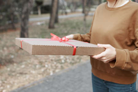Giving a gift to a woman. The concept of a holiday, a surprise