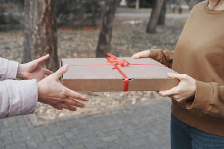 Giving a gift to a woman. The concept of a holiday, a surpriseの写真素材