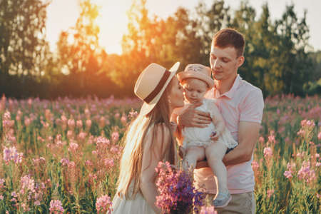 a happy family walks through a flower meadow. Love and spring bloomingの写真素材