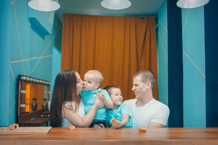 the family eats cakes. dinner at the bakery. feast in the kitchen. the butchering of the food. a woman cuts a pie with a knifeの写真素材