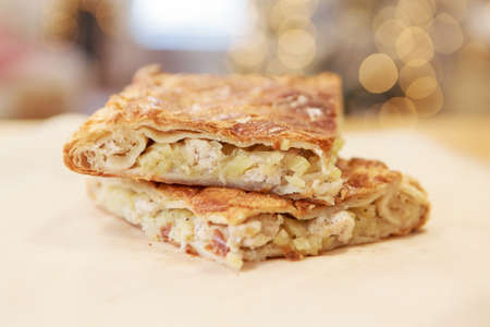 Chicken and potato pie on the dining table. The food is ready to eat. Puff pastry. kitchen utensils for cookingの写真素材
