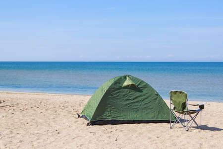 travel to the sea. tent and camping chair on the beach.の写真素材