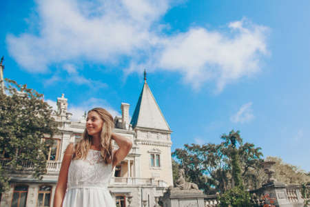 young beautiful girl in summer dress. Travels around the European city in the summer. Cheerful,...