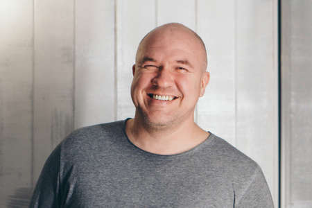 bald handsome man in gray clothes on white backgroundの写真素材