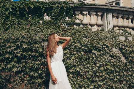 young beautiful girl in summer dress. Travels around the European city in the summer. Cheerful, smiling lady. old houses, paving stones, vintage style, old Europeの写真素材