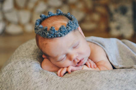 the face of a child with a bandage with flowers on his head close-upの写真素材