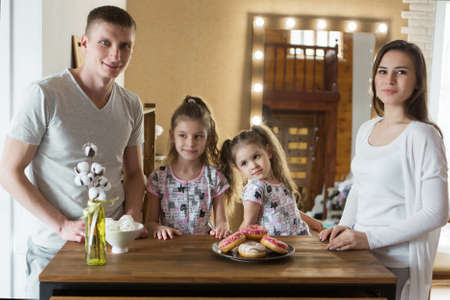 the family eats cakes. dinner at the bakery. feast in the kitchen. the butchering of the food.の写真素材