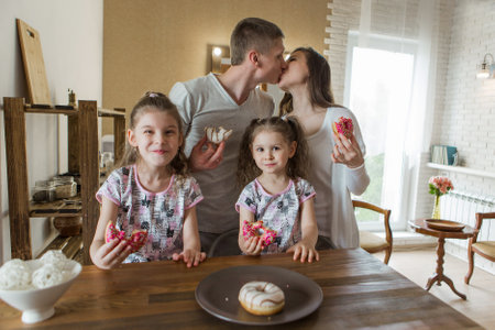 the family eats cakes. dinner at the bakery. feast in the kitchen. the butchering of the food.の写真素材