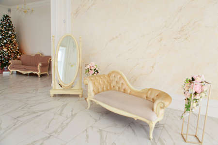 Festive interior: christmas tree and sofa with pillows, gifts. The concept of Christmas and the New year.の写真素材