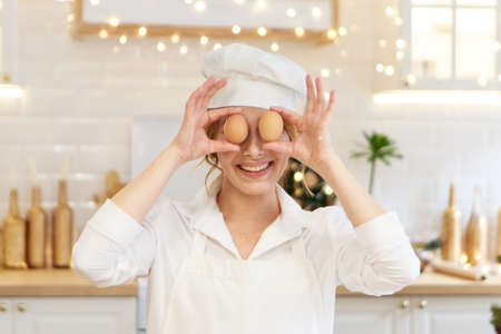 the chef is in the kitchen in protective clothing. The hostess is preparing a Christmas dinner. New Years holidaysThe cook prepares pastriesの写真素材