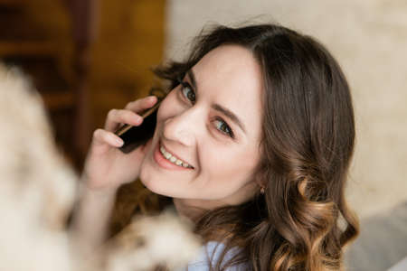 work at home: a girl in bed with smartphone. businesswoman connect. remote work. shop on the couch. shopping via the internetの写真素材