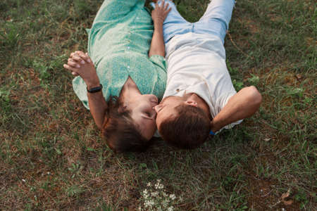 couple in love hugs. man and woman lying. Valentines day on green grassの写真素材