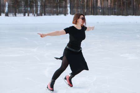 figure skater on ice. the girl is skating. ice under the open sky. No makeup in winter, red cheeksの写真素材