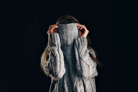 Portrait of girl pulling her trendy sweater over head having fun.の写真素材