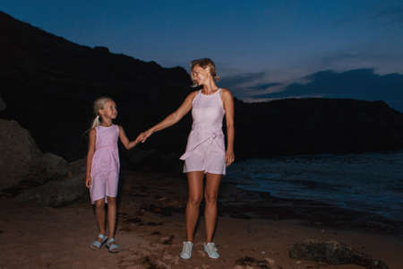 vacation at sea. A family walks along the beach. family holding handsの写真素材