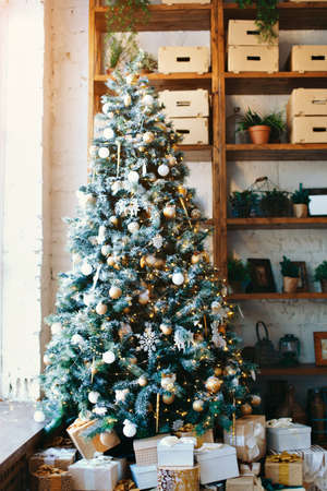 warm cozy beautiful modern design of the room in delicate light colors decorated with Christmas tree and decorative elements fireplaceの写真素材
