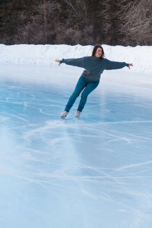 figure skater on ice. the girl is skating. ice under the open sky. No makeup in winter, red cheeksの写真素材