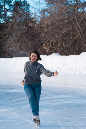 figure skater on ice. the girl is skating. ice under the open sky. No makeup in winter, red cheeksの写真素材
