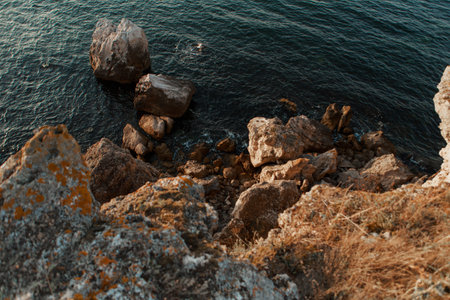 Sunset on the sea, rocks and waves. A trip to the islands, a ticket to paradise. Beautiful background, splashの写真素材