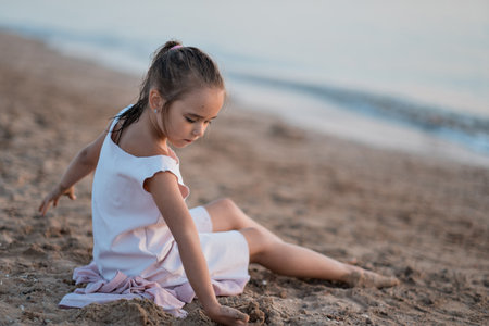 girl playing on the beach at sunset. Family holiday. High quality photo.の写真素材