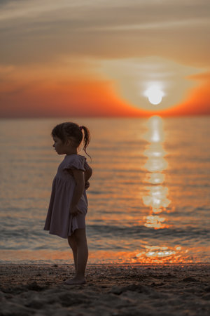 girl playing on the beach at sunset. Family holiday. High quality photo.の写真素材