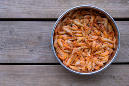 The top view prawns is a seafood. Bring it to boil until cooked to make an orange color look appetizing. In silver tray That was placed on brown wooden block. Copy spaceの写真素材