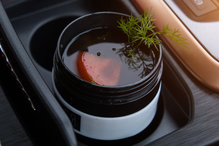 Soup with a tomato and a crop raised with a glass. A glass of coffee in the car. Traveling with the...